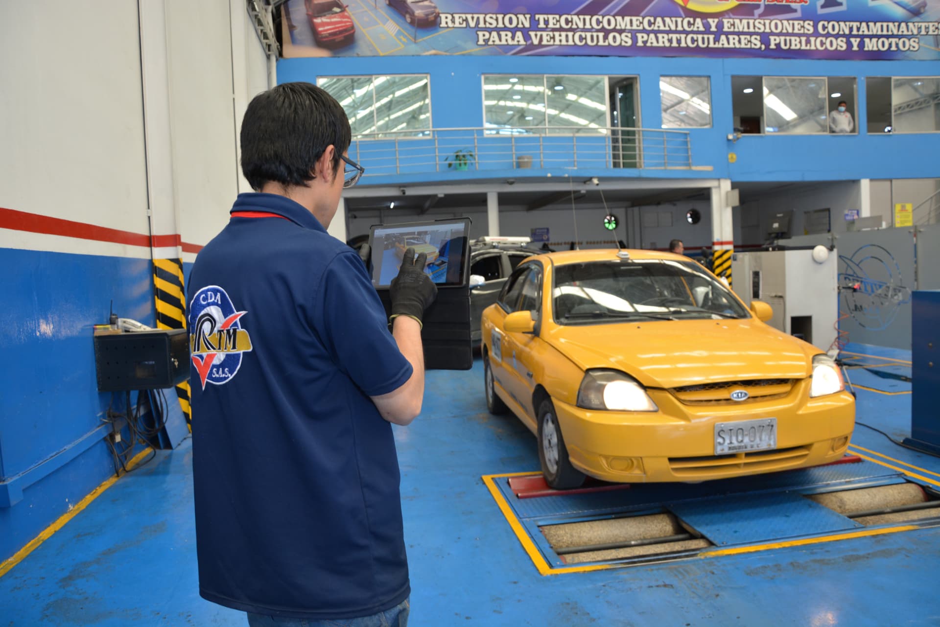 Técnico de Revisión Técnico Mecánica y CÍA S.A.S registrando la inspección de un taxi en tableta